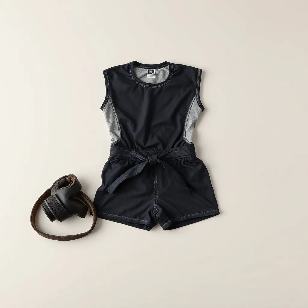 Neatly folded grappling rashguard and accessories on a clean neutral background with visible fabric texture